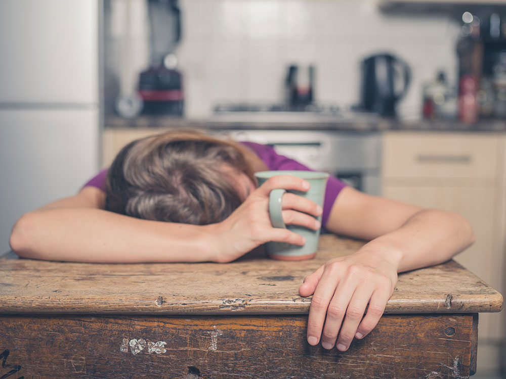 exhausted woman passed out with a grip on her coffee